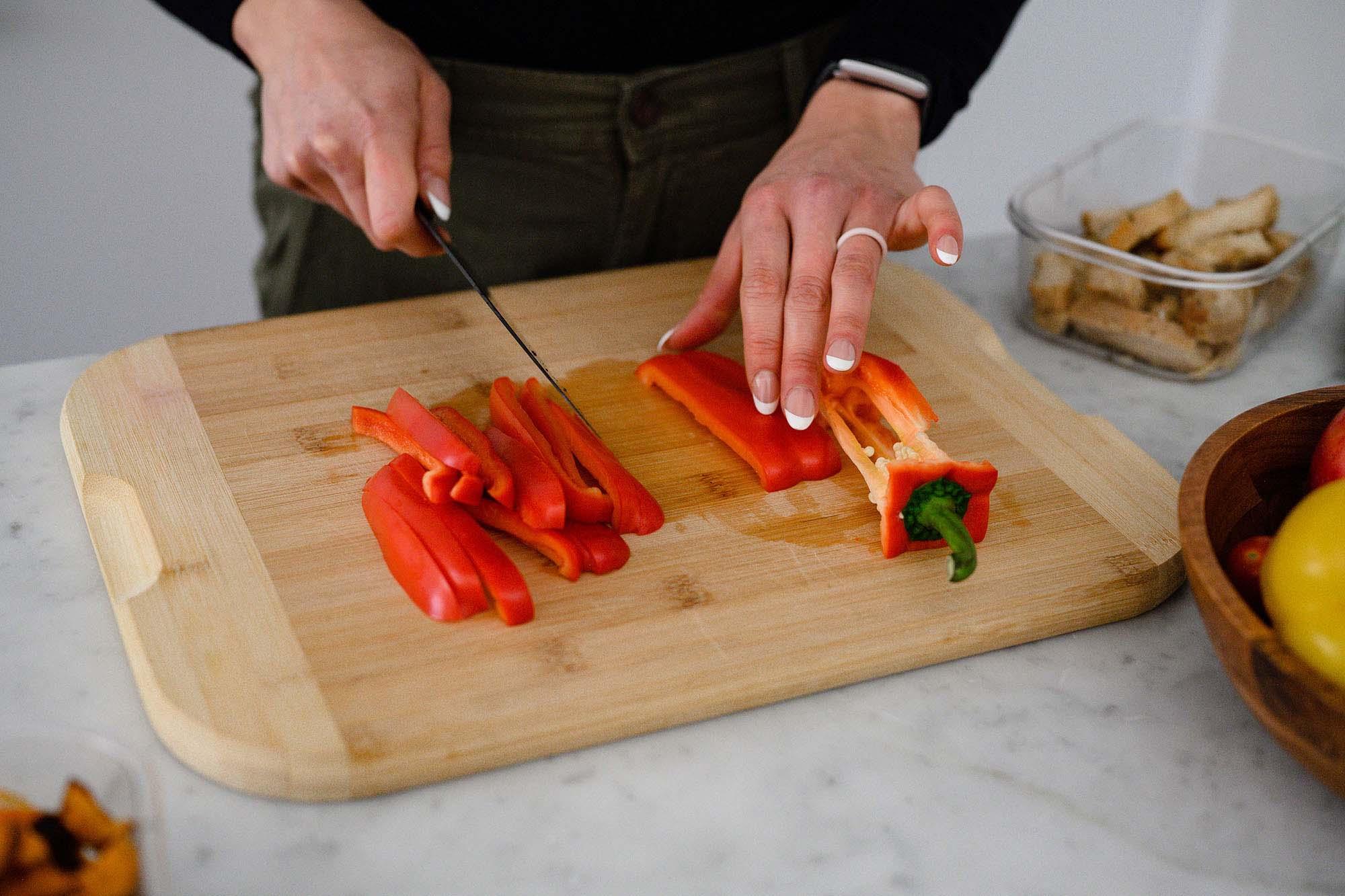 Picture of woman cutting a bell pepper in the kitchen